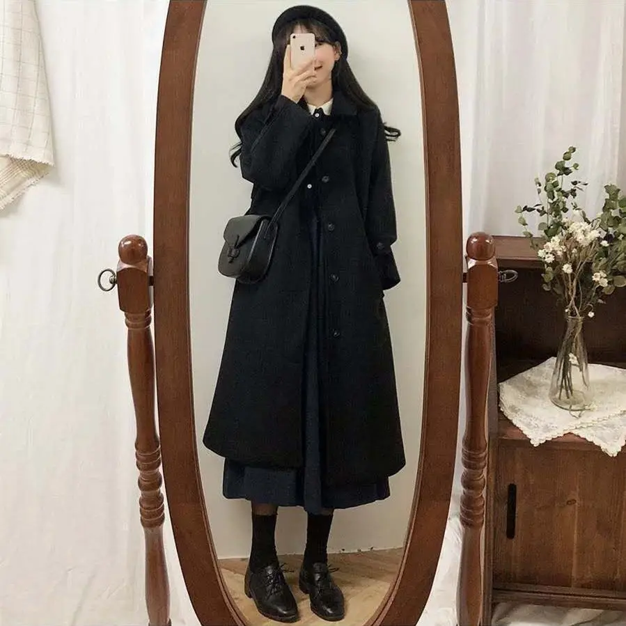 A newly - launched pure black woolen coat for autumn and winter. It is of mid - to - long length, knee - length, loose - fitting, thickened, and designed as a blazer. There are button - up designs on the cuffs.